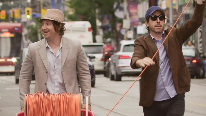 Matt Johnson and Jay McCarrol carrying a big spool of extension cord in Toronto in Nirvanna The Band The Show The Movie