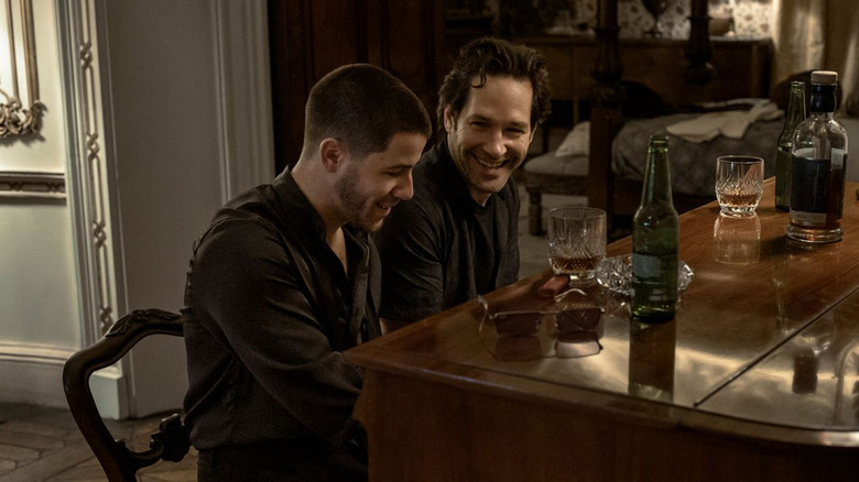 Paul Rudd's Rick Power sits at a piano smiling next to Nick Jonas' Danny Wilson in Power Ballad