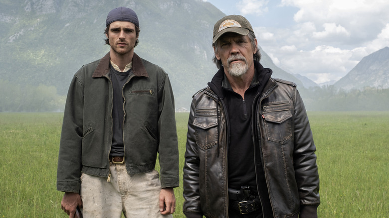 Jacob Elordi as Hig standing next to Josh Brolin as Bangley in a field in The Dog Stars