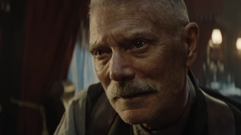 Yeagor Dragunov glimlachend in een autotrein in Sisu: Road to Revenge