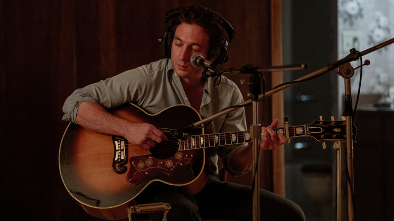 Jeremy Allen White as Bruce Springsteen in a recording studio with an acoustic guitar in Springsteen: Deliver Me From Nowhere