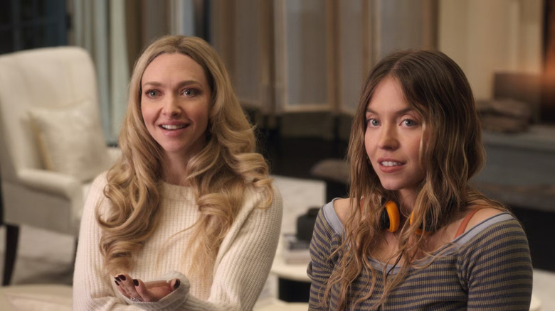 Nina and Millie talking to somebody in the living room in The Housemaid