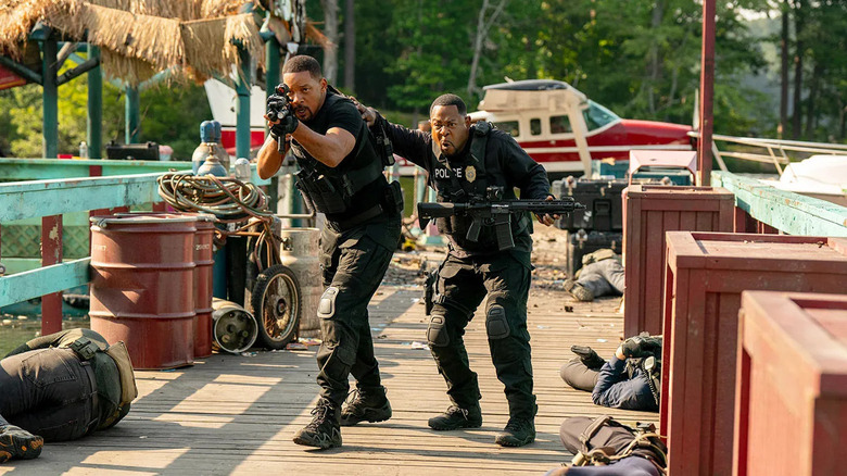 Detectives Lowrey and Bennet, in full armor and holding big guns, walking along a pier in Bad Boys: Ride or Die