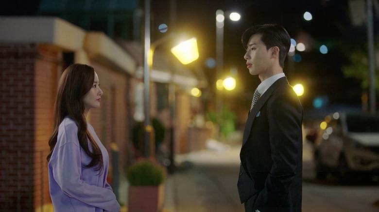 Kim Mi-so (Park Min-young) faces Lee Young-joon (Park Seo-joon) in an evening street in What's Wrong with Secretary Kim?