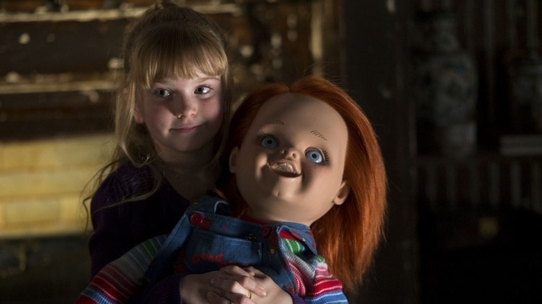 Alice Pierce (Summer H. Howell) holds a smiling Chucky (Brad Dourif) in Curse of Chucky