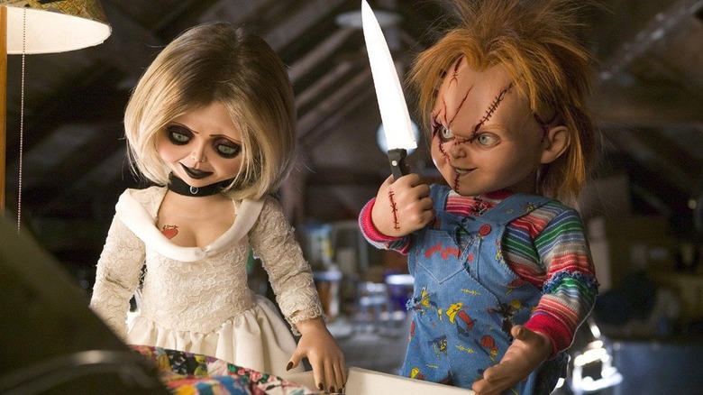 Chucky (Brad Dourif) examines a kitchen knife next to Tiffany (Jennifer Tilly) in Seed of Chucky