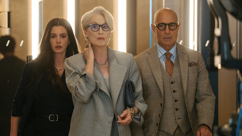 Andy, Miranda, and Nigel walk through a lit hallway looking nervous in The Devil Wears Prada 2