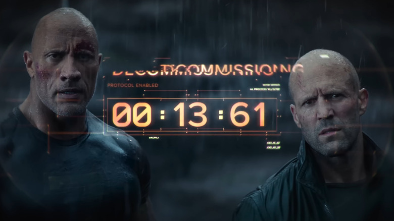 Dwayne Johnson and Jason Statham as Hobbs and Shaw, watching a cyborg shut down, in Hobbs and Shaw