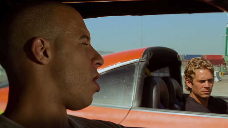 Vin Diesel and Paul Walker as Dom and Brian talking to each other in cars in The Fast and the Furious