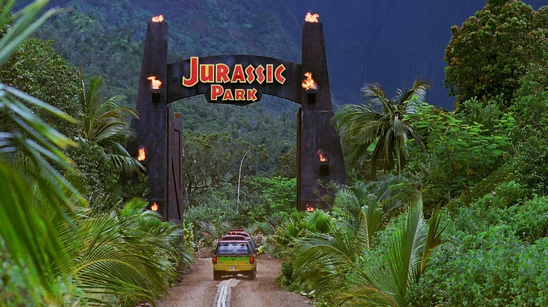 A jeep driving through the entrance to Jurassic Park in Jurassic Park