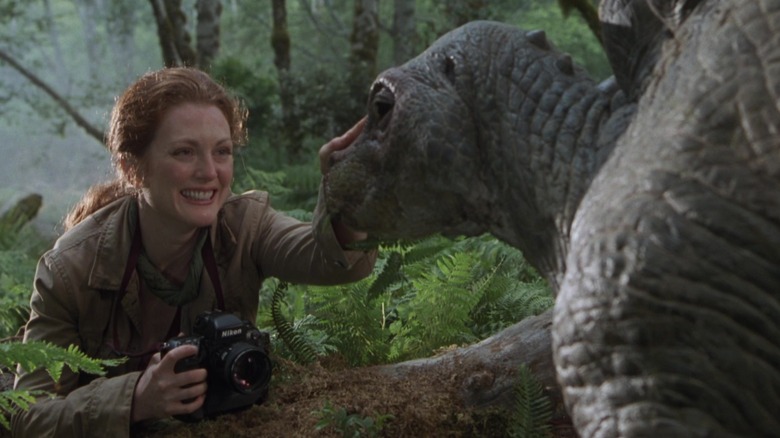 Dr, Sarah Harding with a camera petting a baby dinosaur in The Lost World: Jurassic Park