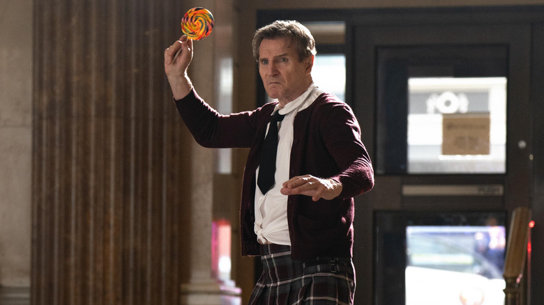 Liam Neeson as Frank Drebin Jr. using a sucker as a weapon in The Naked Gun (2025)