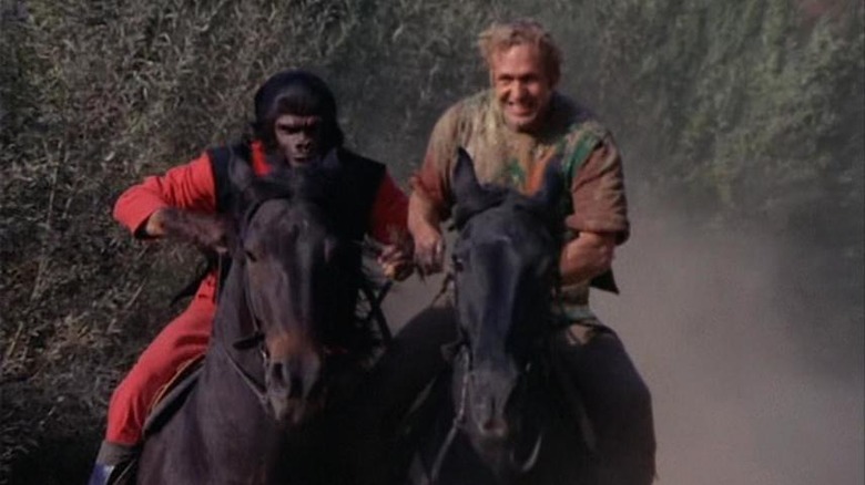 Galen (Roddy McDowall) and Alan Virdon (Ron Harper) gallop on horses in Planet of the Apes (1974)