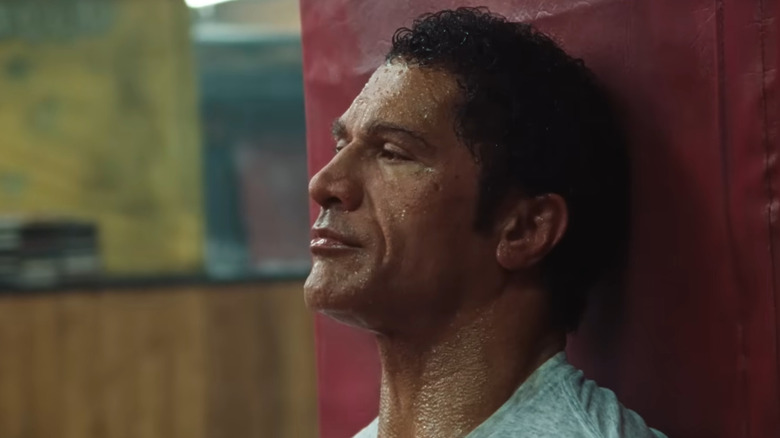 A sweating Mark Kerr sitting against a beam in The Smashing Machine