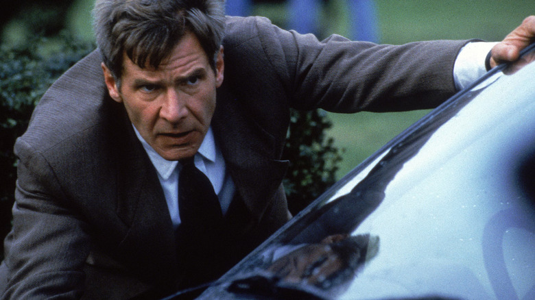 Jack Ryan looking intensely over a car in Patriot Games
