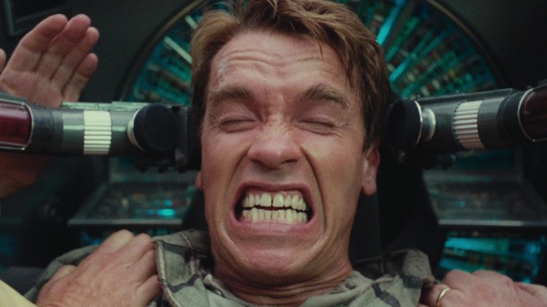 Arnold Schwarzenegger as Douglas Quaid grimacing wildly in Total Recall (1990)