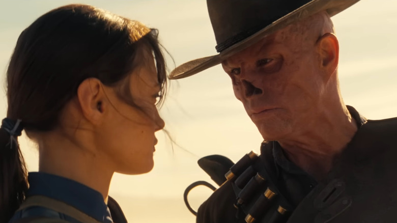 Walton Goggins as The Ghoul standing in a desert looming over Ella Purnell as Lucy in Fallout season 2
