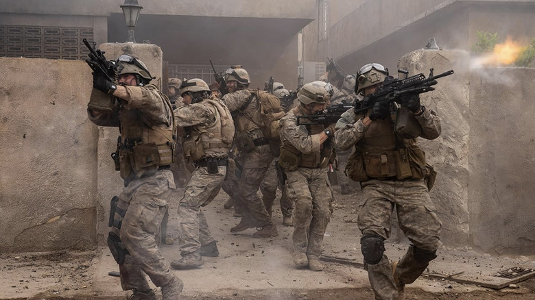 A group of soldiers exit a building with their guns raised in Warfare