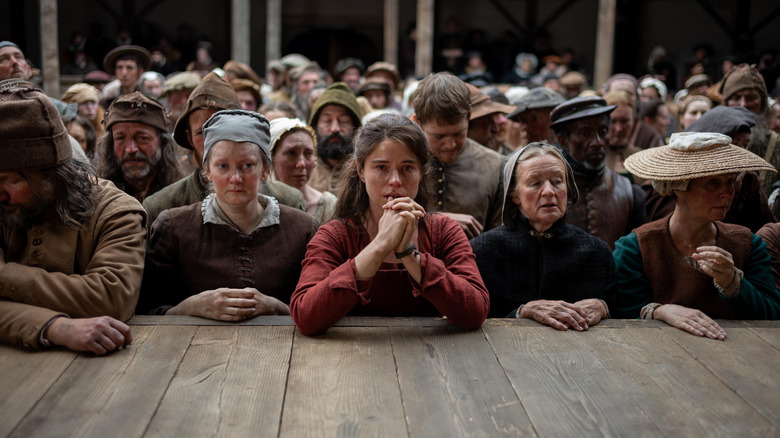 Jessie Buckley as Agnes Hathaway watching a stage play with a crowd in Hamnet