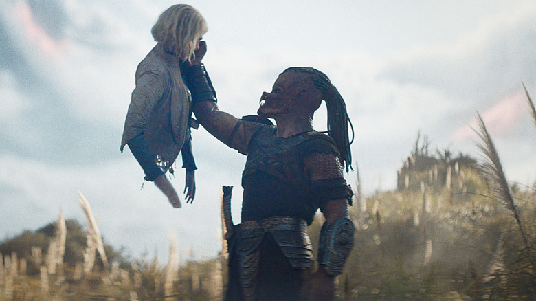 Dek raising Thia with one arm in "Predator: Badlands"