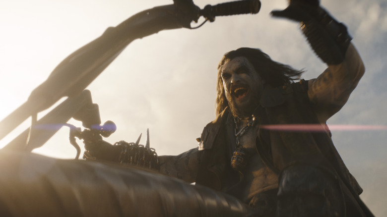 Lobo screaming as he ride his motorcycle through some bad guys, brutally murdering them in Supergirl