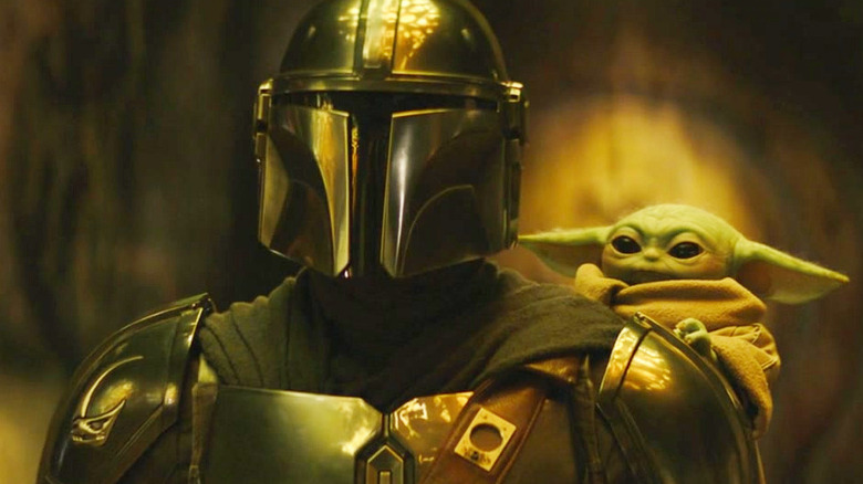 Pedro Pascal as Din Djarin and Grogu standing together in The Mandalorian and Grogu