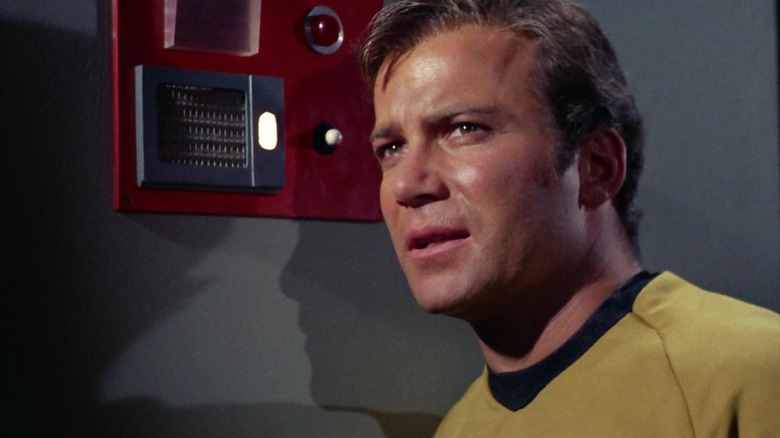 Kirk looking sweaty next to a communication panel on Star Trek