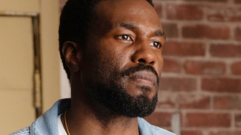 Yahya Abdul-Mateen II as Simon Williams standing in front of a brick wall in Wonder Man