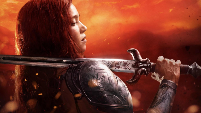 Matilda Lutz as Red Sonja, resting a sword on her shoulder, in promotional artwork for Red Sonja (2025)