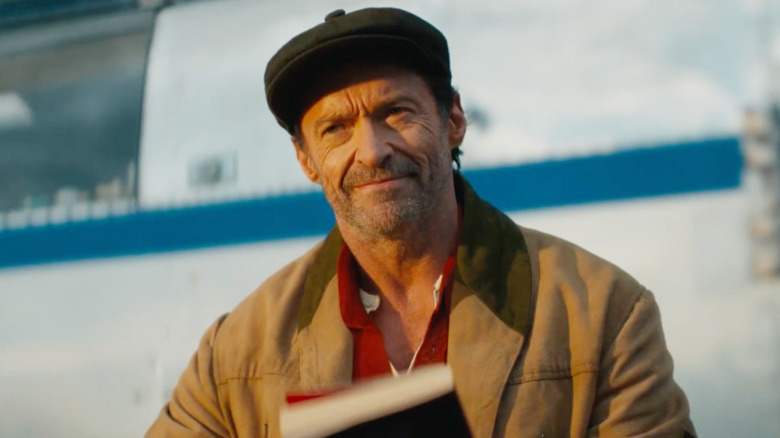 Hugh Jackman as George Hardy holding a book in The Sheep Detectives