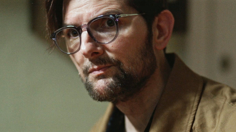 Adam Scott's Ohm Bauman is seen in closeup against a plain background in Hokum