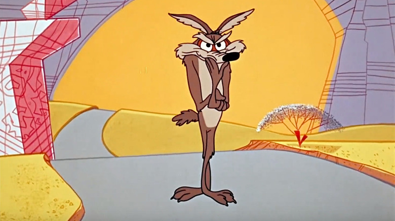 Wile E. Coyote in front of what is clearly a boulder painted with a landscape
