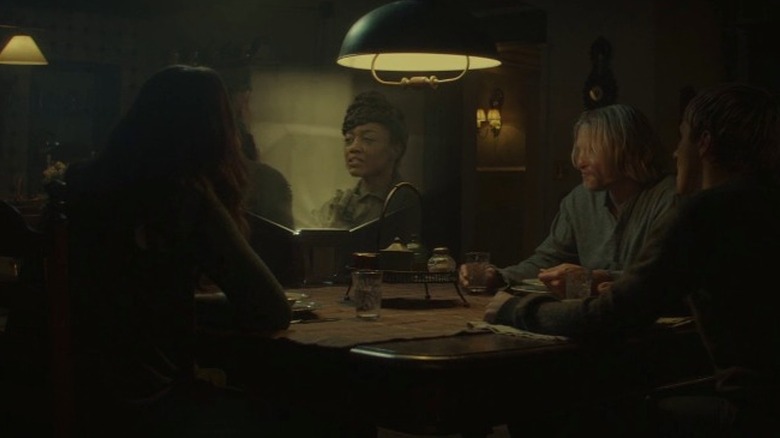 Katniss, Haymitch, and Peeta watch a broadcast of Commander Paylor getting sworn in as president