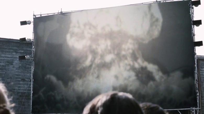 A large screen at a public square showcasing a bomb explosion
