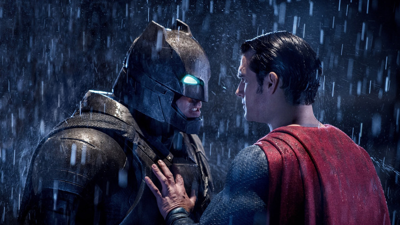 Ben Affleck as Batman in his metal batsuit face-to-face with Henry Cavill as Superman in the rain in Batman v Superman: Dawn of Justice