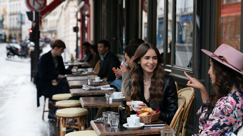 Emily and Mindy eating outside at a bistro on Emily in Paris