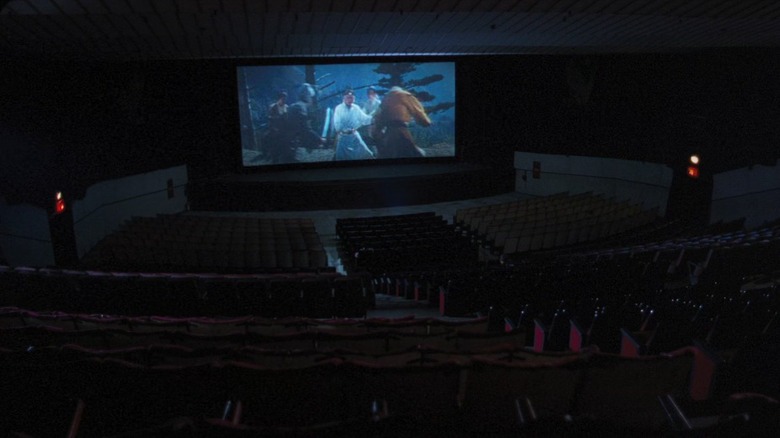 Le vaste intérieur d'une salle de cinéma projetant un vieux film dans Goodbye, Dragon Inn