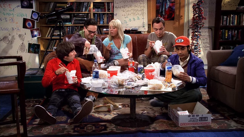 Kaley Cuoco as Penny sitting on a couch in an apartment next to Johnny Galecki as Leonard Hofstadter, Simon Helberg as Howard Wolowitz, Jim Parsons as Sheldon Cooper, and Kunal Nayyar as Raj Koothrappali in The Big Bang Theory