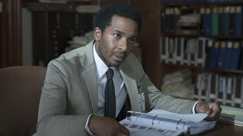 Henry sitting at a desk while wearing a suit in Castle Rock