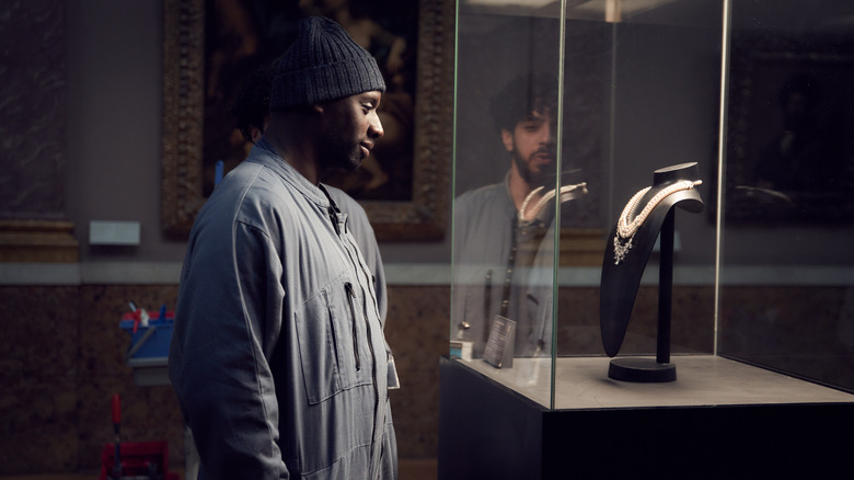 Assane looking at the diamond necklace in its case in Lupin