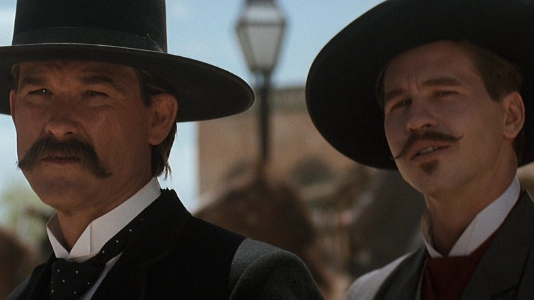 Kurt Russell as Wyatt Earp and Val Kilmer as Doc Holliday standing together in Tombstone