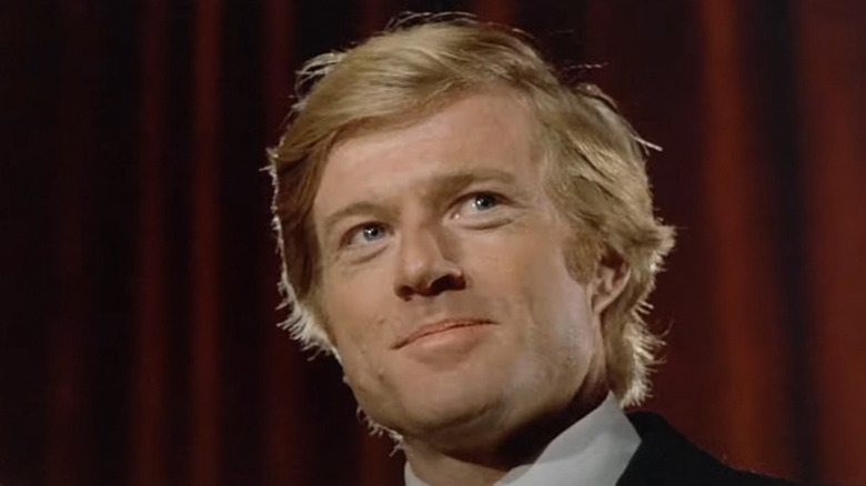 Robert Redford as Bill McKay standing at a podium in The Candidate