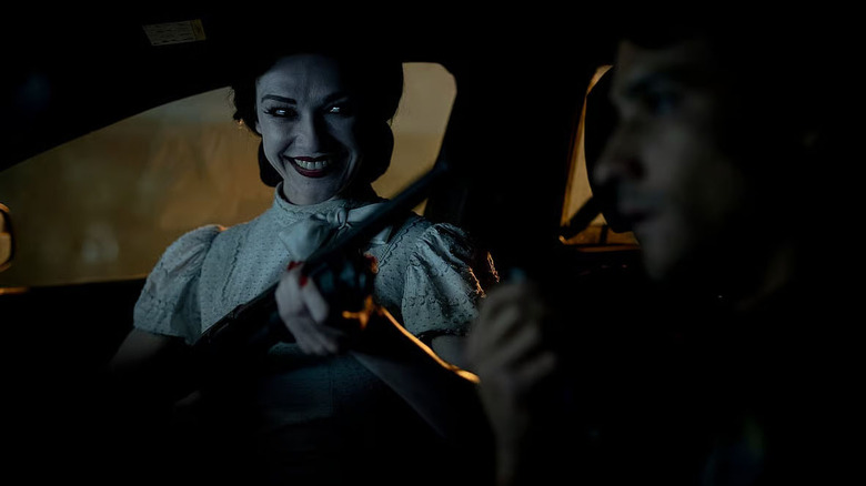 The Doll Girl pulling a gun in Insidious: Out of the Further
