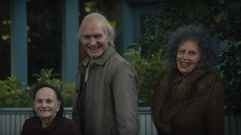Three old demons standing on the street smiling in Insidious: Out of the Further