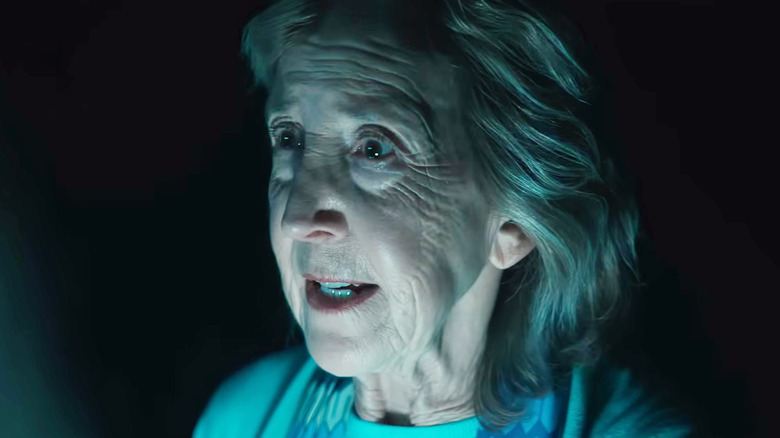 Lin Shaye as Elise standing in the dark in Insidious: Out of the Further