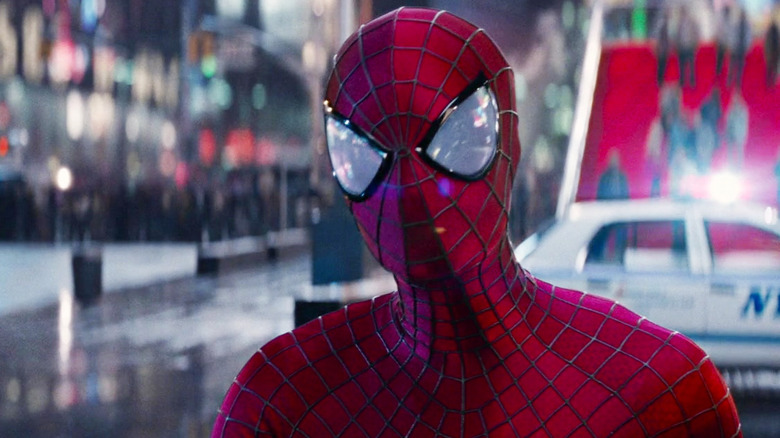 Spider-Man (Andrew Garfield) standing next to a police car in 