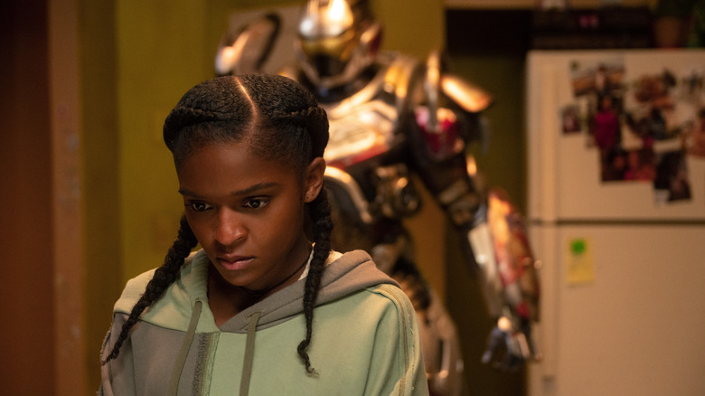 Dominique Thorne as Riri Williams standing in front of her Ironheart armor in Ironheart