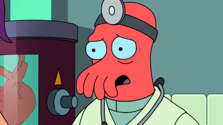 Dr. Zoidberg next to a heart machine talking to Leela on Futurama