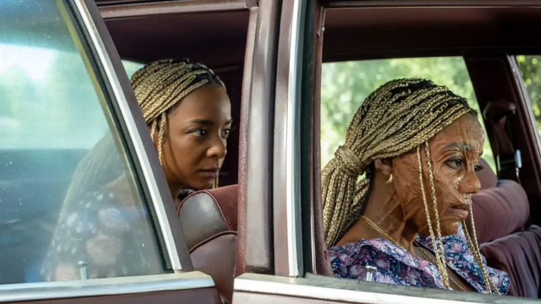 Racine in the backseat of a car, Anaia in the front in Is God Is