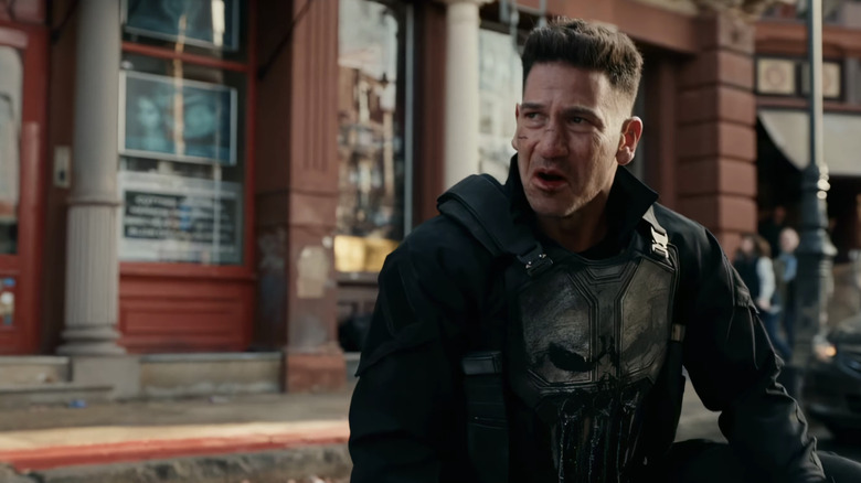 Frank Castle/The Punisher se arrodilla en una calle de la ciudad en Spider-Man: Brand New Day de Jon Bernthal